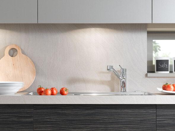 Detailaufnahme einer Küchenzeile mit dunklen Fronten und hellen Hängeschränken